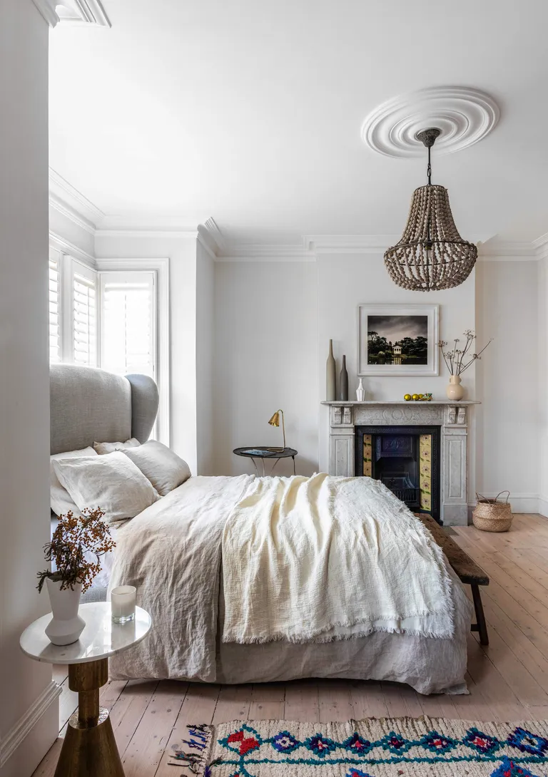 White bedroom with boho touches and large chandelier