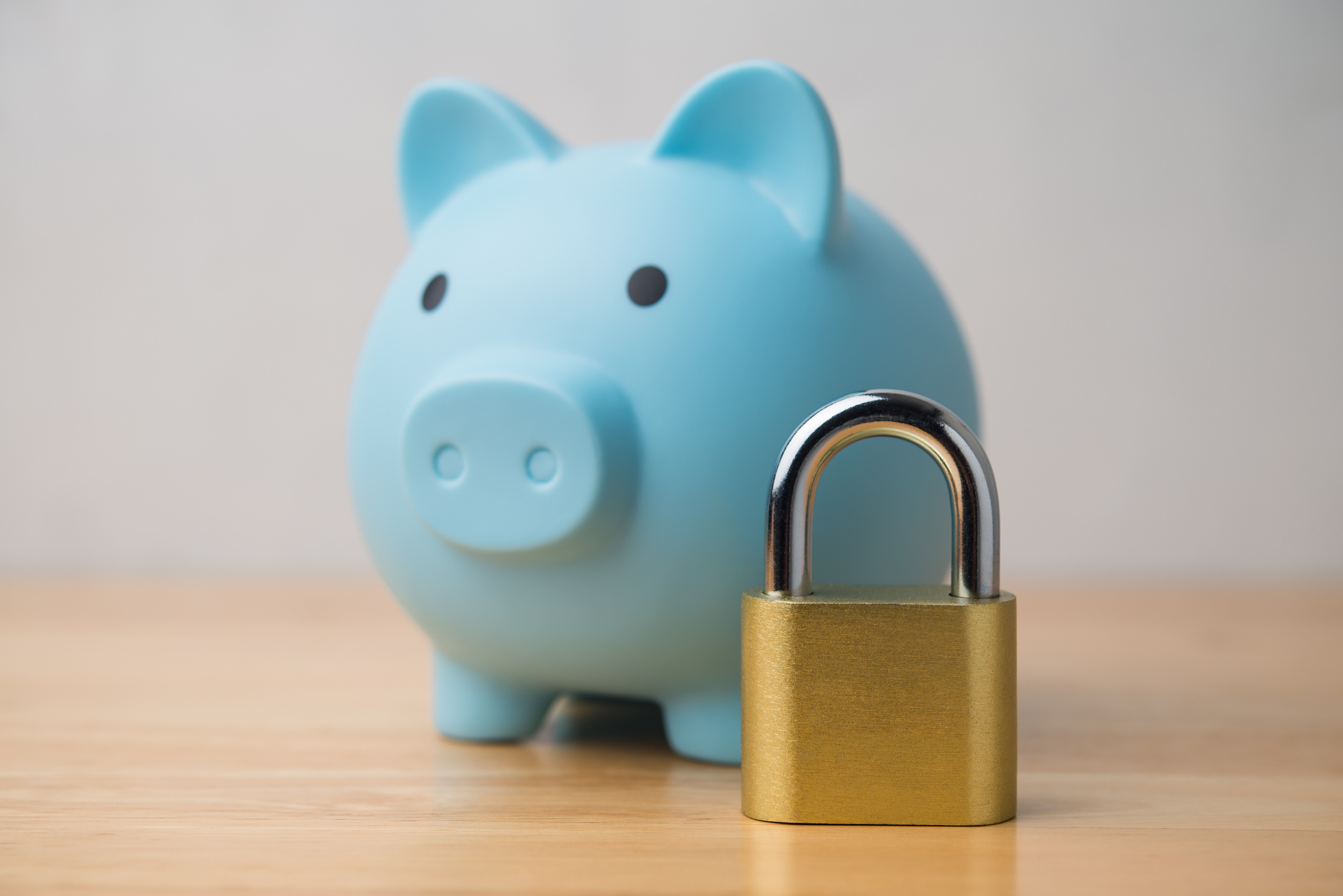 Fixed savings accounts concept. Padlock and blue piggy bank on table 