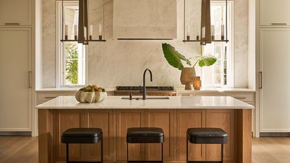 Wooden kitchen with white marble and black stools