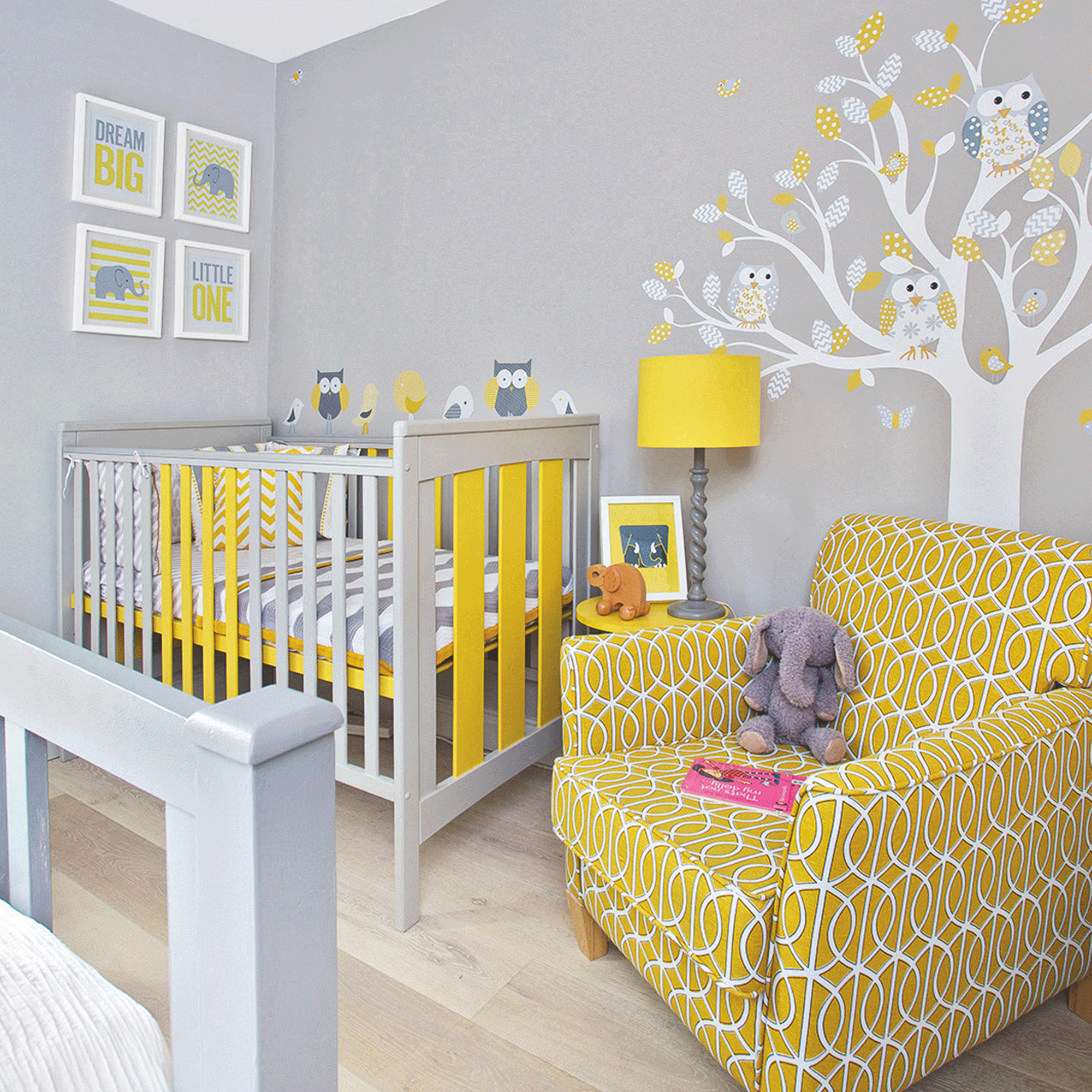 Grey nursery with yellow armchair and tree