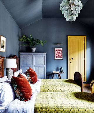 Blue painted bedroom with yellow painted door and accessories, twin room