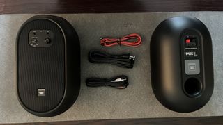 JBL 104-BT speaker kit, including wires, laid out neatly on a desk mat