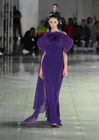 A model walks the runway at the Naeem Khan fashion show during February 2024 New York Fashion Week wearing a sugilite purple gown.