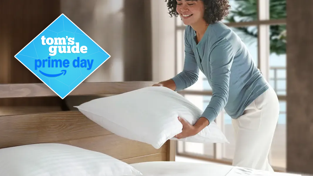 Woman placing the Beckham Hotel Collection Down Alternative white pillows on the bed in a brightly lit room