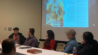 Chris Perkins and the D&D panel discuss the new Player's Handbook at Garycon, with images on a projector behind them