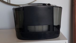 Image shows a side view of the Honeywell Top Fill Cool Moisture Humidifier on a white dresser.