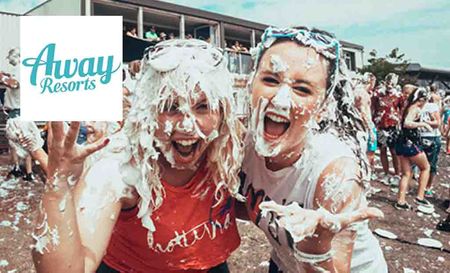 Away Resorts logo placed over an image of two girls covered in paint smiling happy 