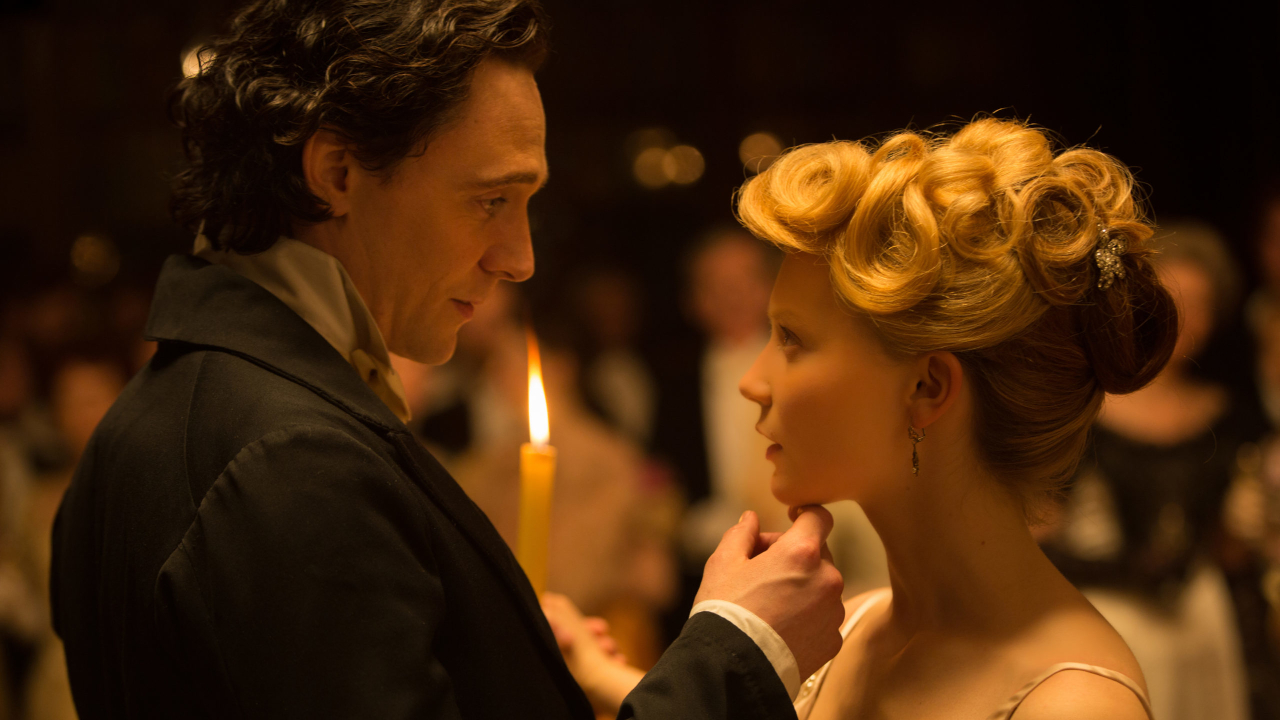 Tom HIddleston lifts up an awe struck Mia Wasikowskas chin in Crimson Peak.