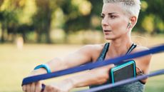 Woman using resistance band outdoors at park