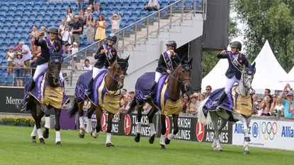 The British team of Tom McEwen, Laura Collett, Ros Canter and Gemma Stevens hold their gold medals aloft on their lap of honour after being crowned world eventing champions