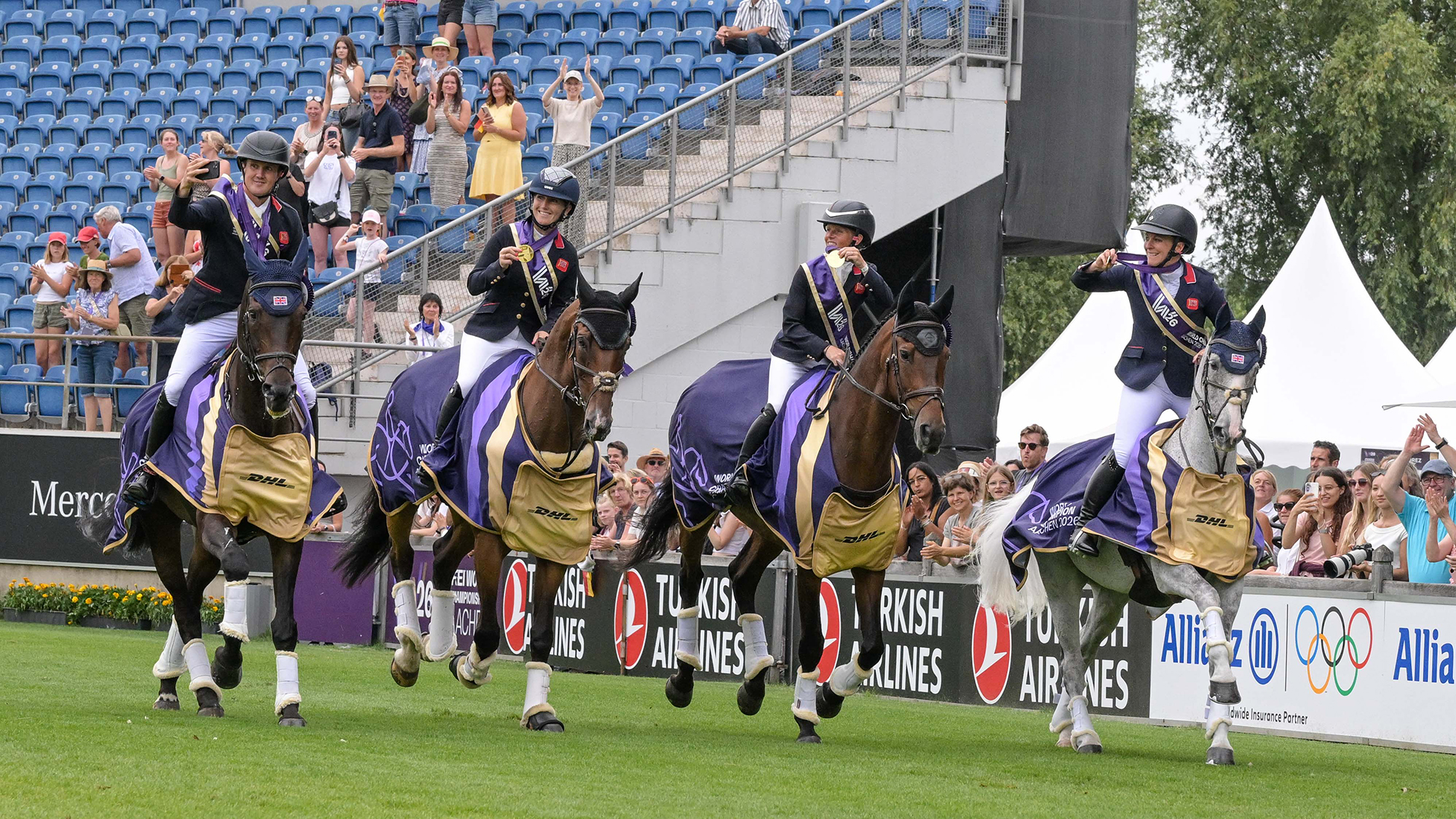 The British team of Tom McEwen, Laura Collett, Ros Canter and Gemma Stevens hold their gold medals aloft on their lap of honour after being crowned world eventing champions