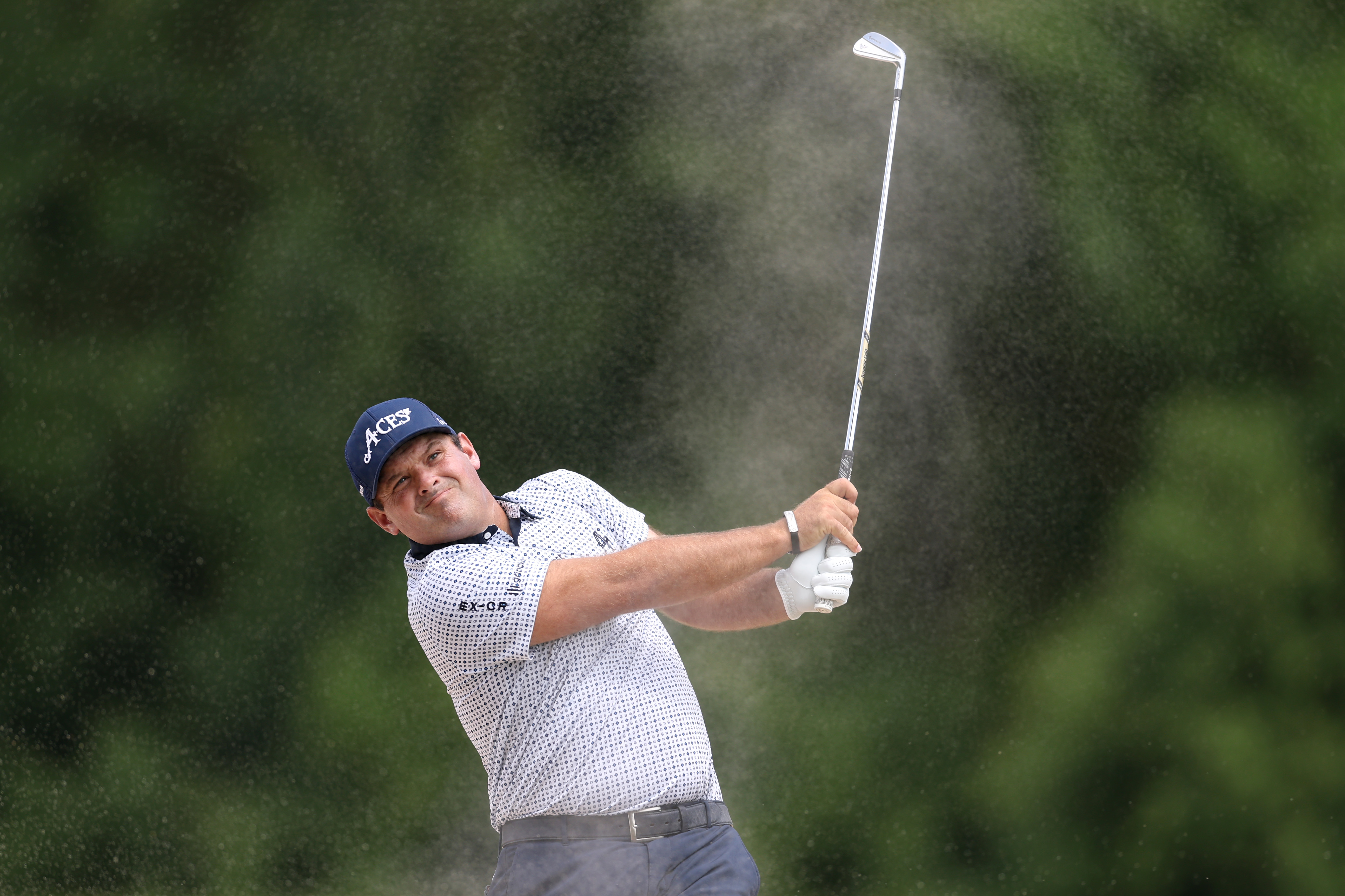 Patrick Reed hits an iron shot from the bunker