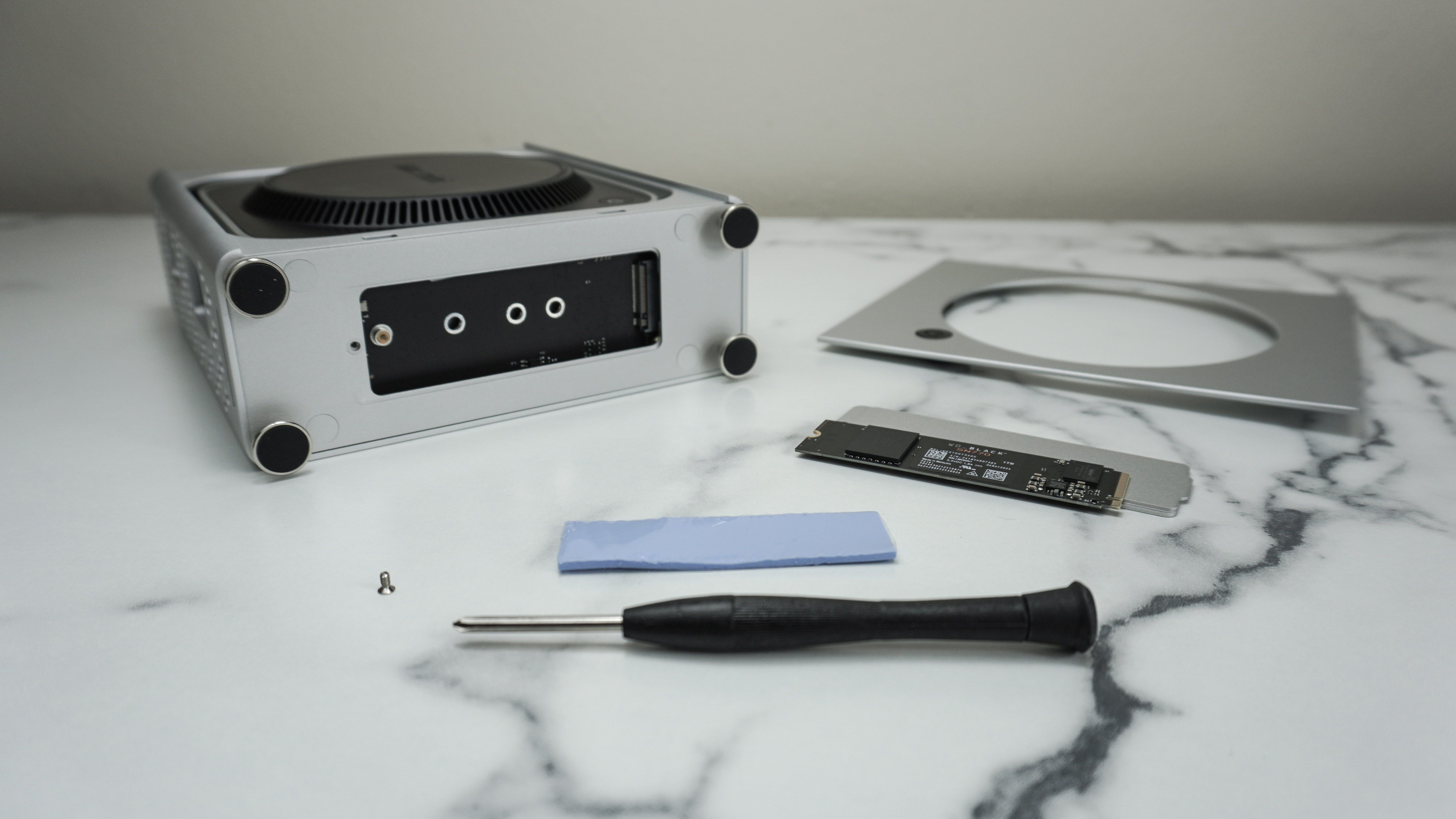 The Orico MiniPro Dock Case next to a screwdriver and an M.2 SSD on a desk