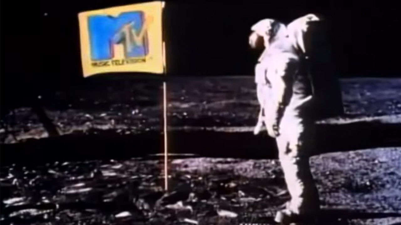 The iconic MTV flag with an astronaut standing next to it.