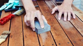a person sanding wood floors – sanding and restoring floors will cut your house renovation costs