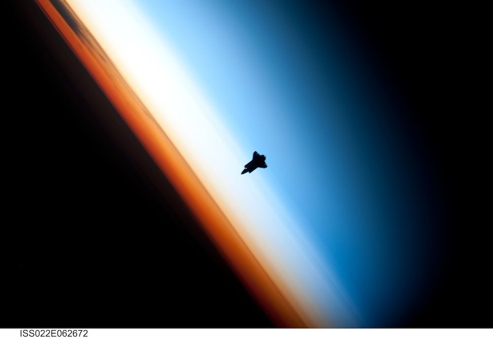 The Space Shuttle Endeavour silhouetted against the atmosphere.