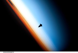 The Space Shuttle Endeavour silhouetted against the atmosphere.