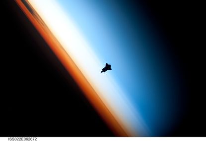 The Space Shuttle Endeavour silhouetted against the atmosphere.