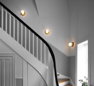 A staircase with 3 staggered wall lights