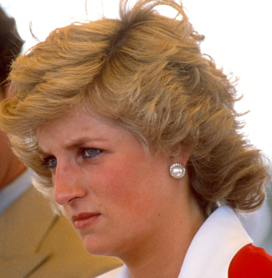 Princess Diana wearing a red and white dress and scowling