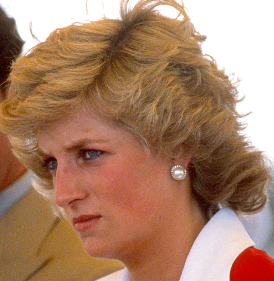 Princess Diana wearing a red and white dress and scowling