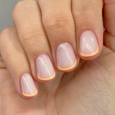 A close-up of a peachy French manicure by Harriet Westmoreland