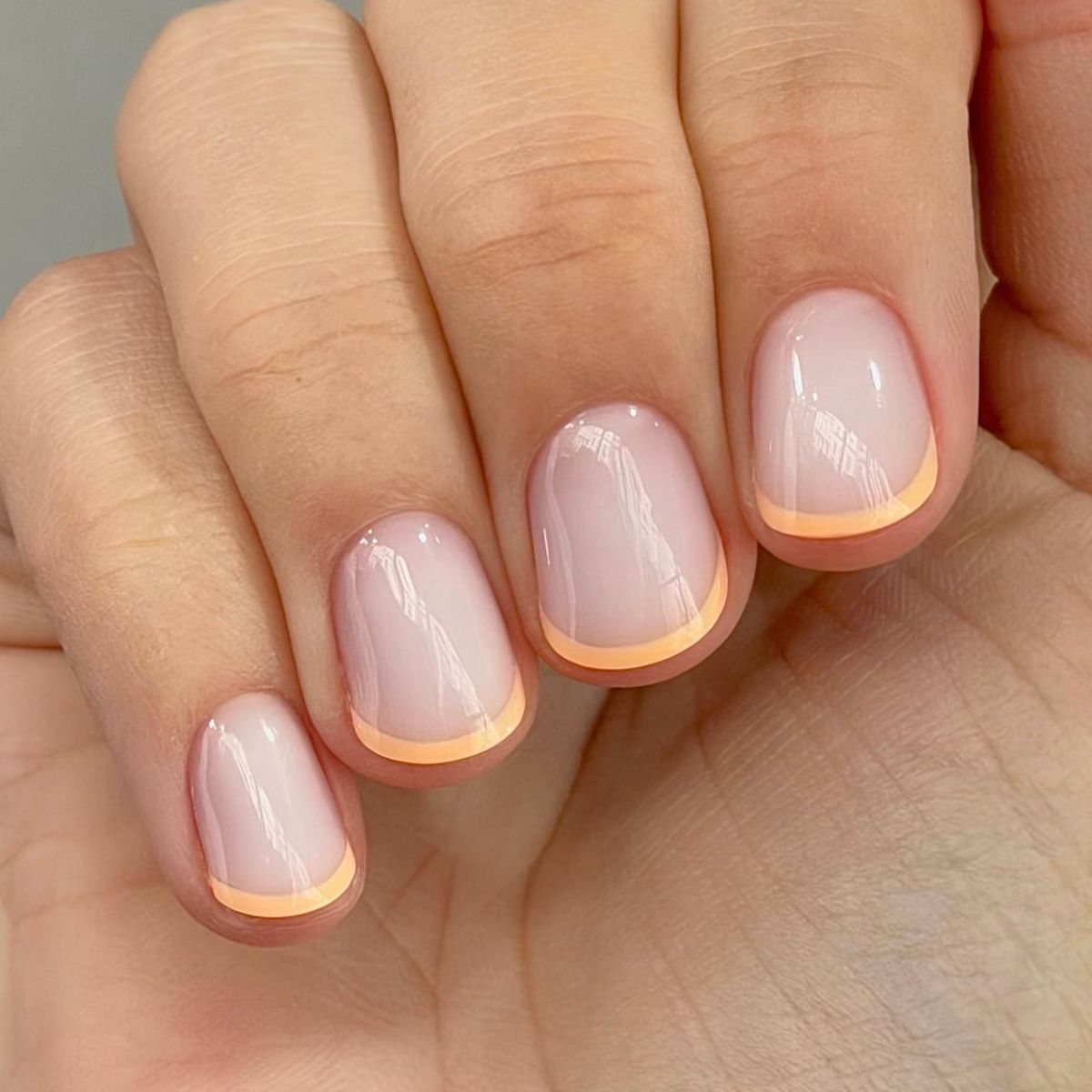 A close-up of a peachy French manicure by Harriet Westmoreland