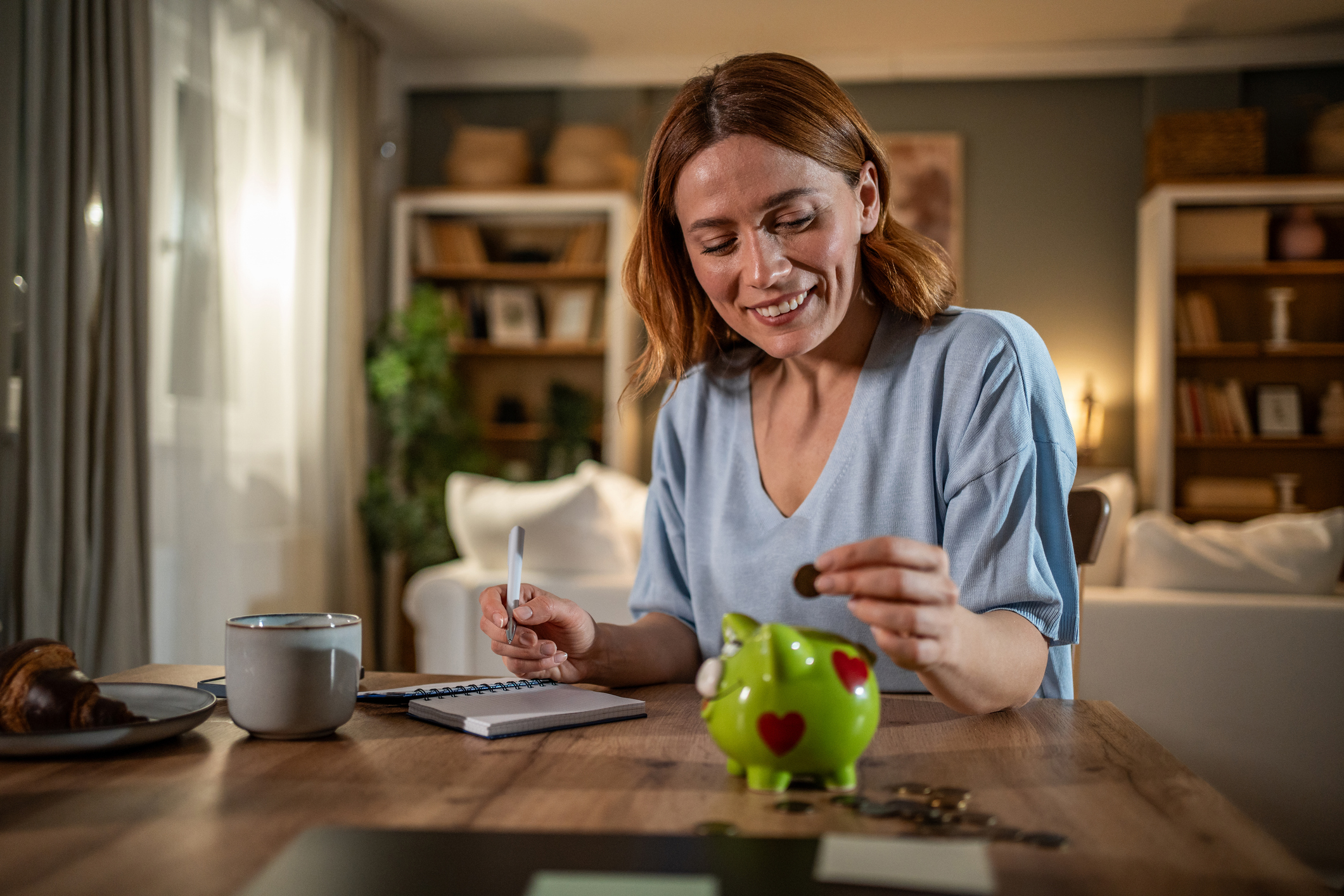 a woman putting some change into a piggy bank