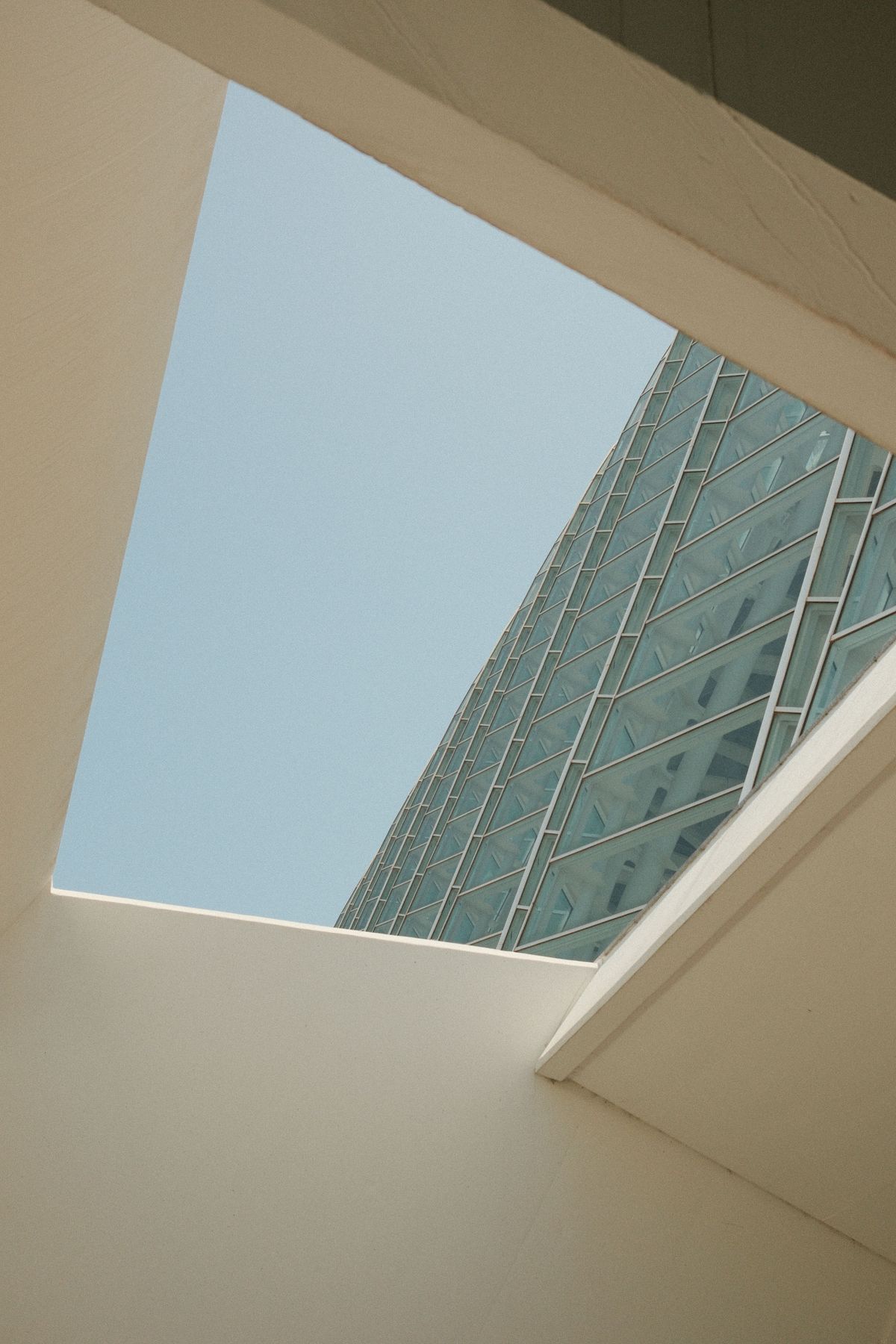 Sky and glass building seen through a gap in a flight of stairs