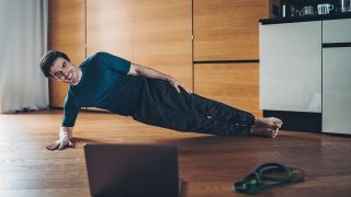 Man performs side plank exercise at home