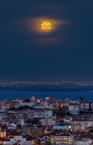 The Blue Moon of March 31, 2018, rises over the Tagus River in this photo taken from a rooftop on Amoreiras Towers in Lisbon, Portugal. On the other side of the river is the Portuguese town of Samouco.