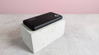 Iniu B41 power bank on plinth on desk with pink background