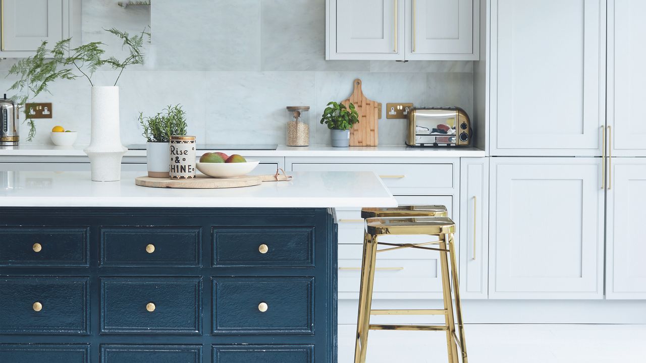 Kitchen with light grey wall cabinets, navy island and kitchen stools