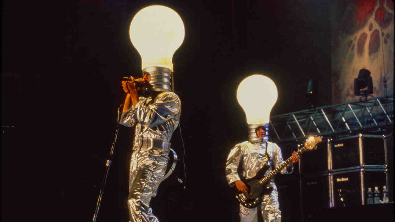 Red Hot Chili Peppers performing onstage at the Woodstock &amp;rsquo;94 festival wearing giant lighbulbs on their heads