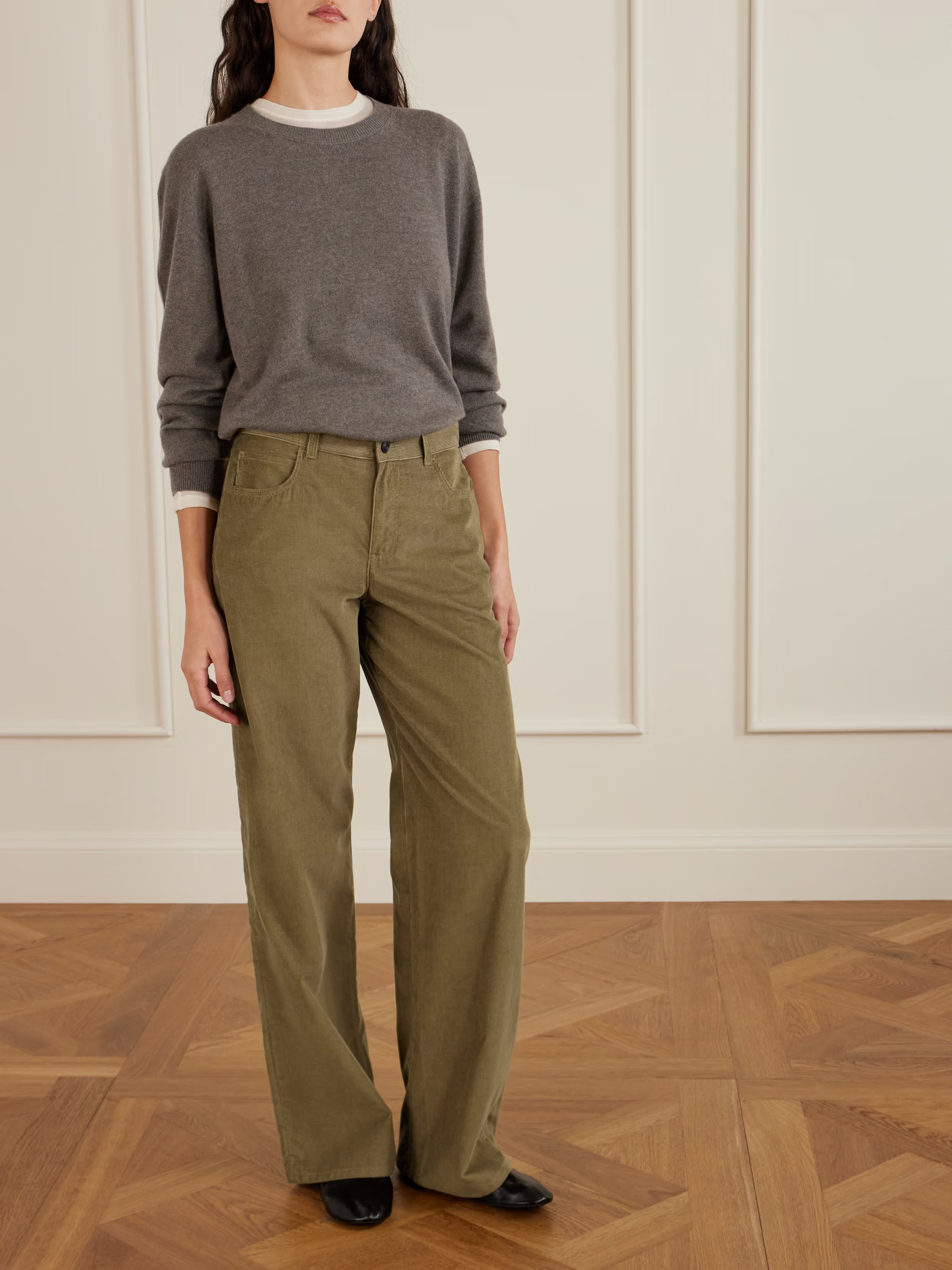A woman wearing khaki corduroy trousers.