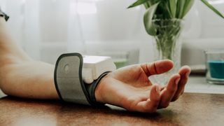 Person's wrist, with blood pressure cuff
