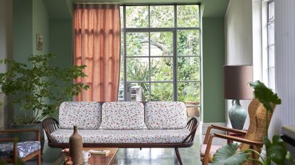 Green painted living room with botanical fabrics and large patio door