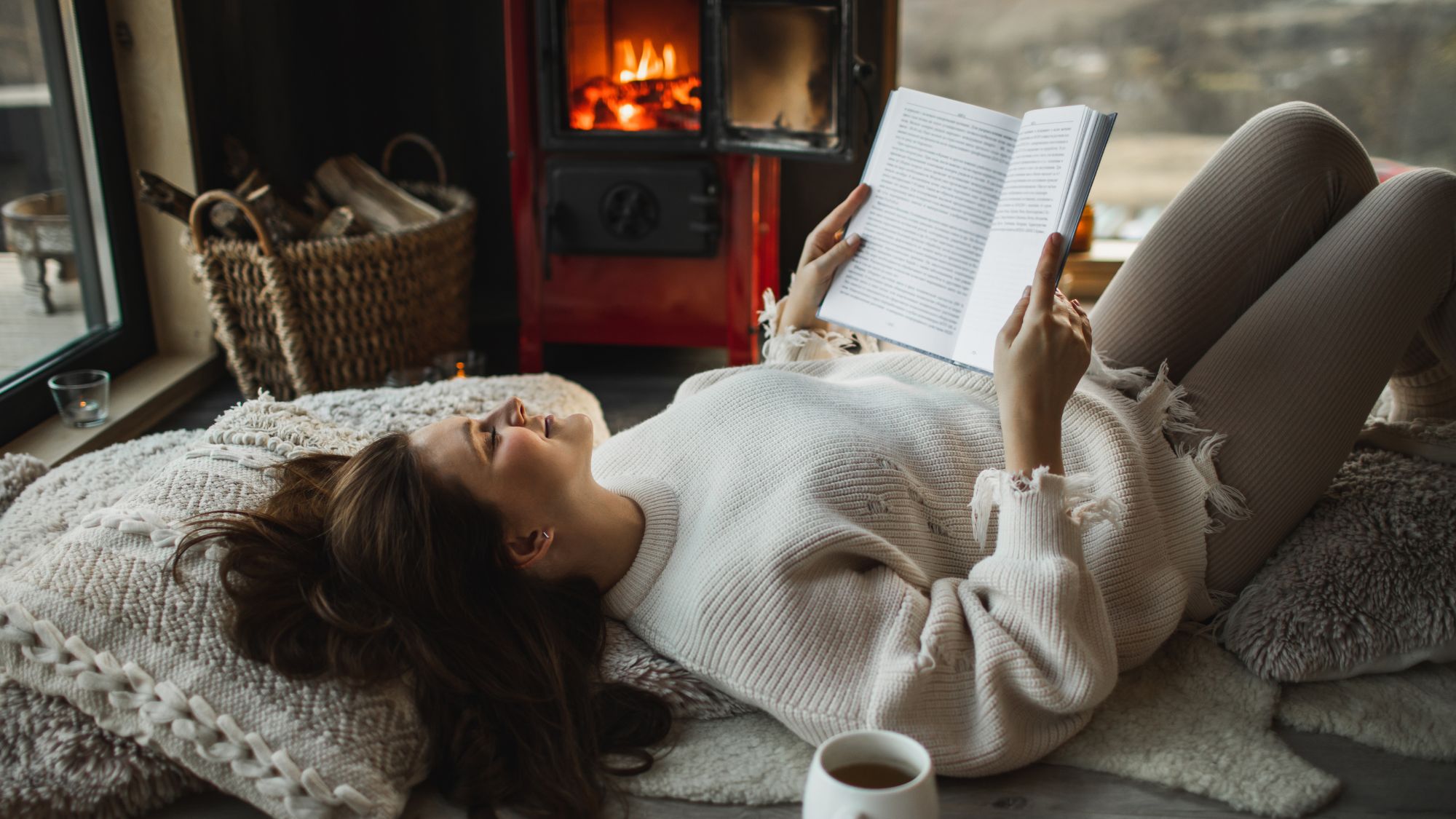 Winter slump: A woman reding her book by the fire