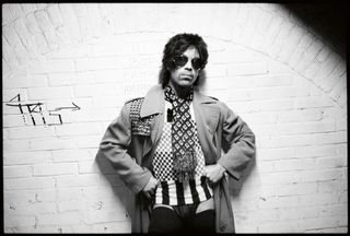 Singer prince against a white brick wall