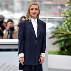 Scarlett Johansson wearing a blazer and button-up top. She's wearing her hair down with a side part. 