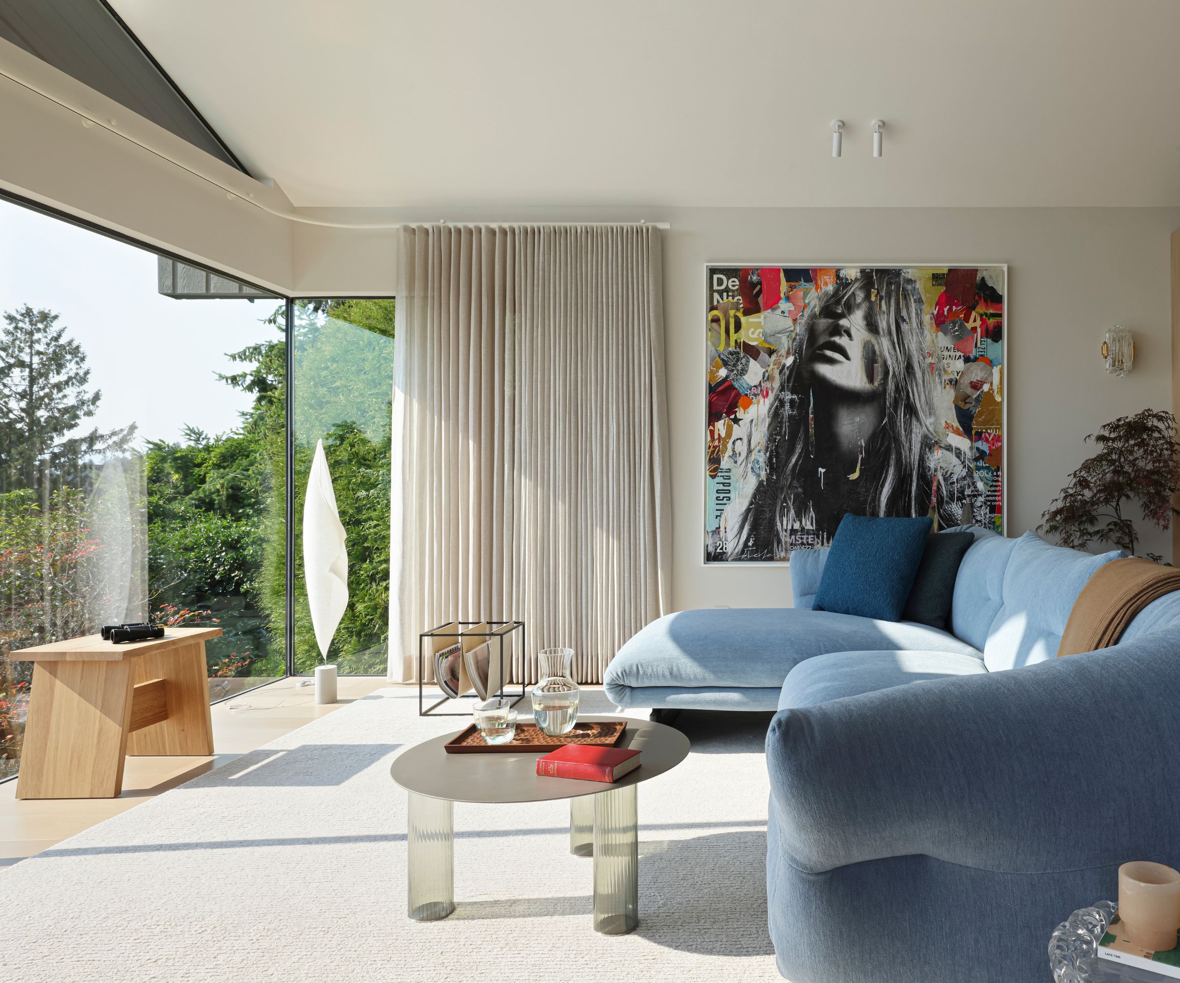 living room blue couch glass wall and modern art