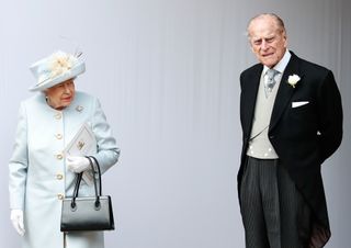Britain's Queen Elizabeth II (L) and Britain's Prince Philip, Duke of Edinburgh (R) standing next to each other outside in Windsor.