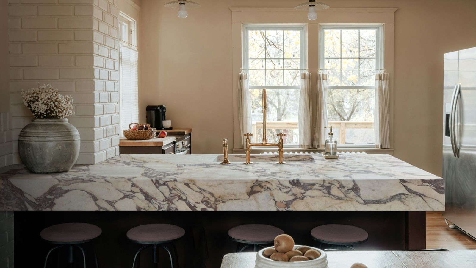 A warm neutral kitchen with marble countertops