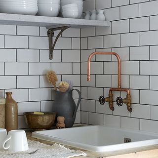 white brick tile wall copper tap and wash basin