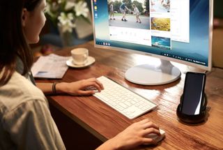 Woman uses desktop computer with Samsung DeX Desktop Experience