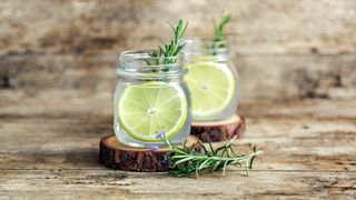 Home remedies for fleas on dogs - jars of lemon and rosemary sat on wooden bench