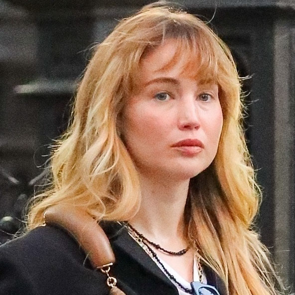 Jennifer Lawrence wearing a black button-up, white T-shirt, black skirt, black flats, and brown leather bag 