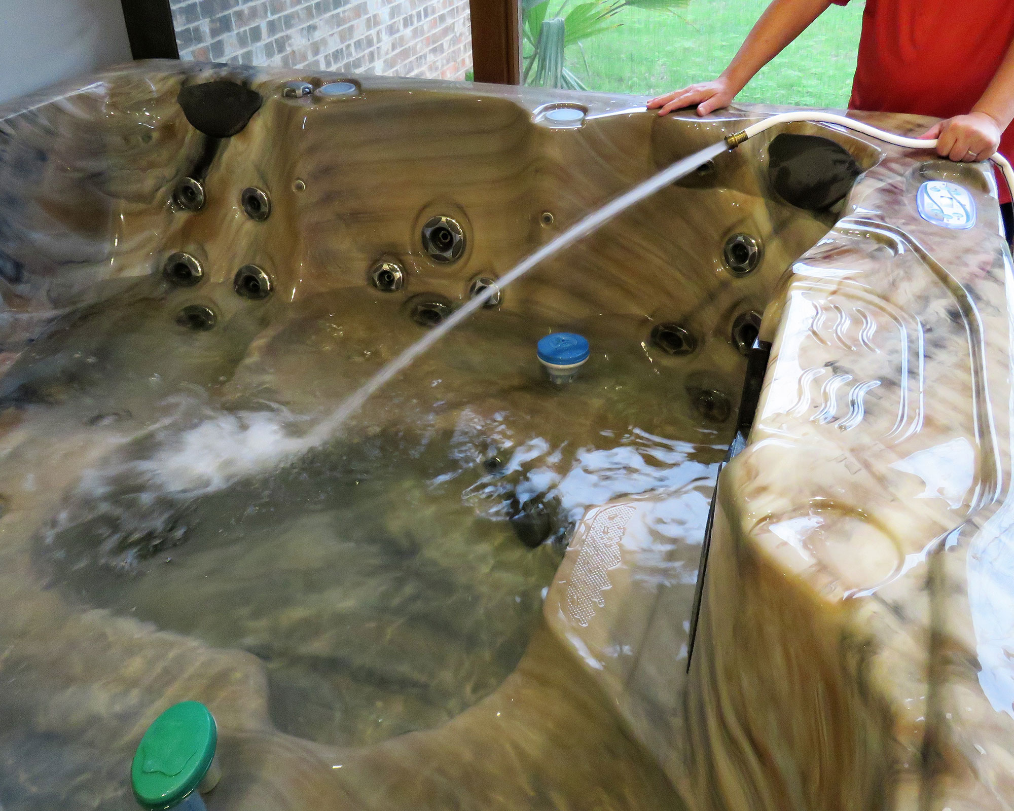 man cleaning an empty hot tub