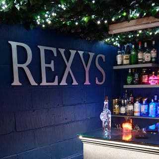 rexys sign with blue wall and drinks