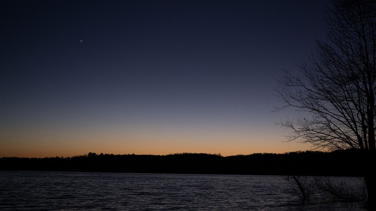 Jupiter (left) and Saturn (right) are seen after sunset above Jordan Lake during the "great conjunction" on Dec. 21, 2020, near Chapel Hill, North Carolina.